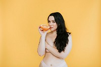 Partially nude woman holding a fresh orange