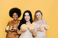 Diverse nude women holding fruits over their breasts