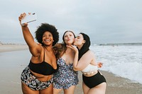 Beautiful confident women taking a selfie at the beach