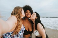 Beautiful confident women taking a selfie at the beach