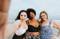 Beautiful confident women taking a selfie at the beach