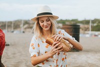 Woman eating a sandwich at a beach picnic