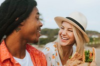 Couple dating and eating sandwiches at a beach picnic