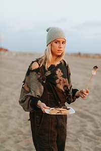 Woman having a s'more at the beach