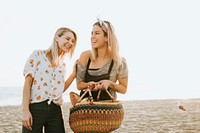 Friends walking at the beach with a picnic basket