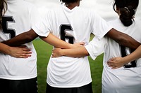 Female soccer players huddling and standing together