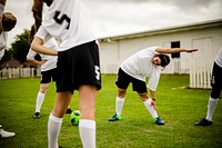 Female soccer team players stretching pre game