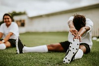 Female football player stretching before a match