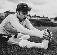 Football player stretching before a match