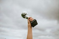 Human hand holding a trophy cup