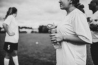 Female football player holding a water bottle