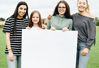 Group of young women showing a blank board