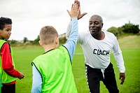 Football coach doing a high five with his student