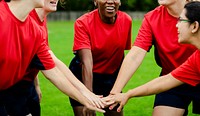 Female rugby players stacking their hands together