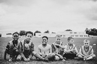 Junior football team sitting on the grass