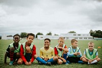 Junior football team sitting on the grass