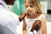 Pediatrician measuring the temperature of a young girl