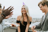 Cheerful friends celebrating a birthday party at a rooftop