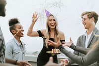 Cheerful friends celebrating a birthday party at a rooftop