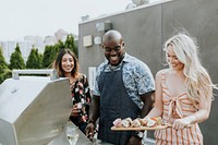 Happy friends grilling at a rooftop party