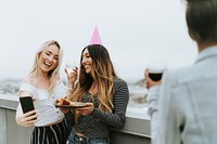 Birthday girl taking a selfie with her friend at a rooftop
