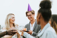 Cheerful friends celebrating at a rooftop birthday party