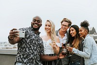 Diverse group of friends taking a selfie at a rooftop party