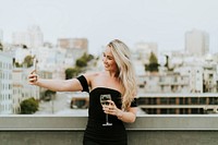 Cheerful woman taking a selfie at a rooftop party