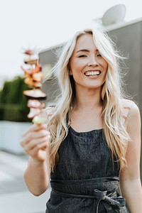 Cheerful woman with a barbeque skewer