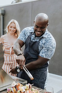 Happy couple preparing barbeque skewers