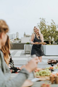 Cheerful woman serving vegan barbecue to her friends