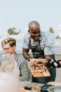 Cheerful chef serving grilled vegan barbeque skewers