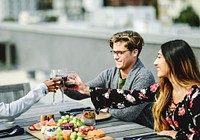 Friends toasting at a rooftop vegan dinner party