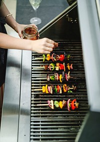 Woman cooking vegan barbecue on a charcoal grill