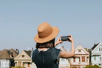 Woman taking a photo of the Painted Ladies of San Francisco, USA