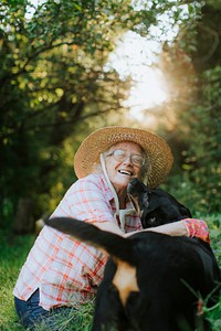 Happy senior woman getting kisses from her dog