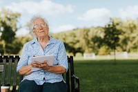 Senior woman writing down her memories into a notebook