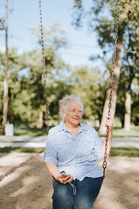Happy elderly woman on a swing