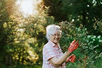 Senior woman tending to the flowers in her garden