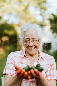 Senior woman holding organic jalapeno peppers from her own garden