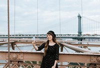 Woman taking a selfie on the Brooklyn Bridge, USA