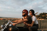 Biker couple riding down the road in the sunset