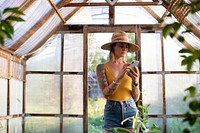 Gardener using her phone in the greenhouse