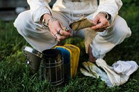 Beekeeper preparing the smoker on the grass