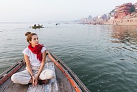 Western woman on a boat exploring the River Ganges