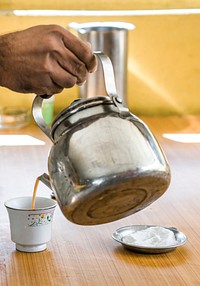 Man pouring chai tea into a cup
