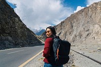 Female backpacker walking on a mountainous highway