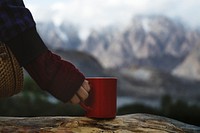 Woman holding a mug overlooking the Himalaya mountains