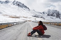Young woman sitting on the Karakoram highway