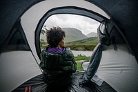 Woman sitting in a tent while it&#39;s raining